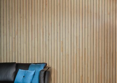 Wooden covering for ceiling and wall in a living room with a sofa (NORTO Bech)