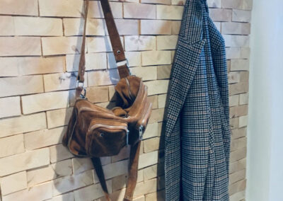 Wall decoration of solid pine wood in a hallway. Hocks on the wall and a jacket and a bag.