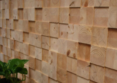 Wooden wall decoration of face blocks. Bench with a plant