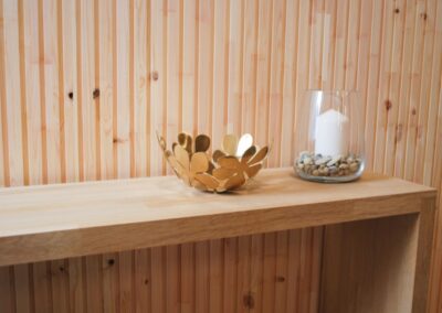 Untreated wooden wall covering of slats and a bench of wood