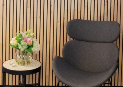 Wooden wall covering of slats with black painted grooves in a reception