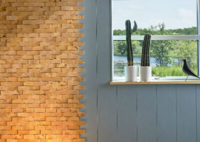 Wooden wall decorations of untreated face blocks and blue painted wall panels and a window. Light placed on the floor