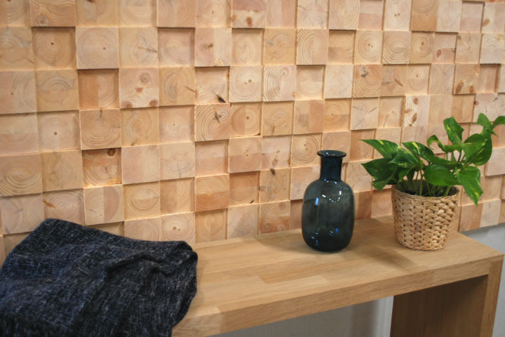 Wooden wall covering of face blocks. Bench with a blanket, vase and flower