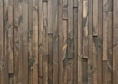 Wooden wall decoration of slats with brown oil.