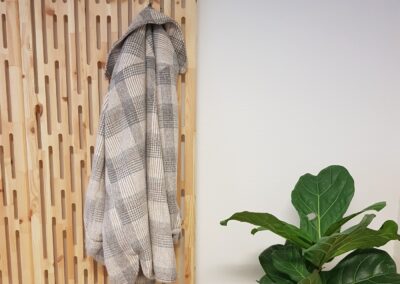 NORTO Toft akustikpanel som garderobeløsning med jakke og plante i højre side