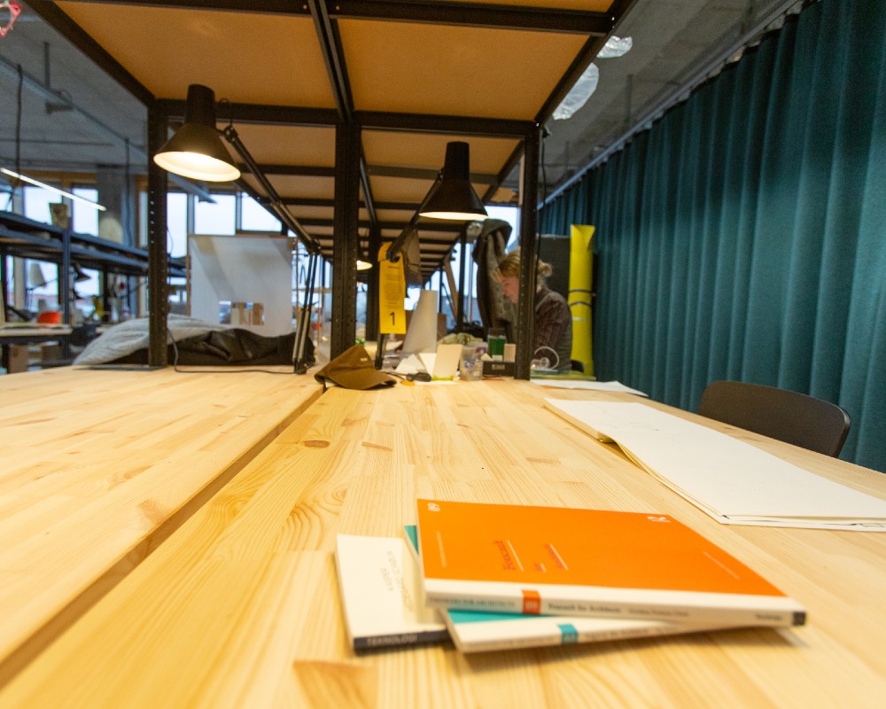 Close-up af skrivebordsplader i upcyclet fyrretræ på tegnestue på Arkitektskolen Aarhus